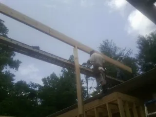Carpenter setting a ridge beam over a new addition frame — Ice Dam Removal by Roofing Brothers in Cotopaxi