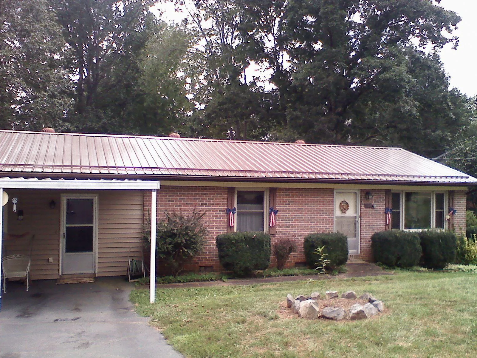 Bronze metal roof and carport on a brick ranch home — Roof Repair work by our crew in Cotopaxi
